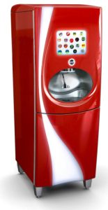 Red beverage dispenser with thermoformed enclosure shown in a real-world fast-food setting, with a touchscreen panel, dispensing opening, and curved silver-white accent panels.